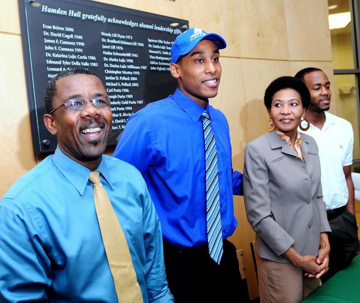 Hamden Hall basketball player Darren Payen, center, signed a national letter of intent to play basketball for Hofstra University at the Beckerman Athletic Center in Hamden. He is pictured with his father Jean-Filbert Payen, left, mother Solange Payen, right, and brother Fred Payen, far right. Photo by Arnold Gold/New Haven Register