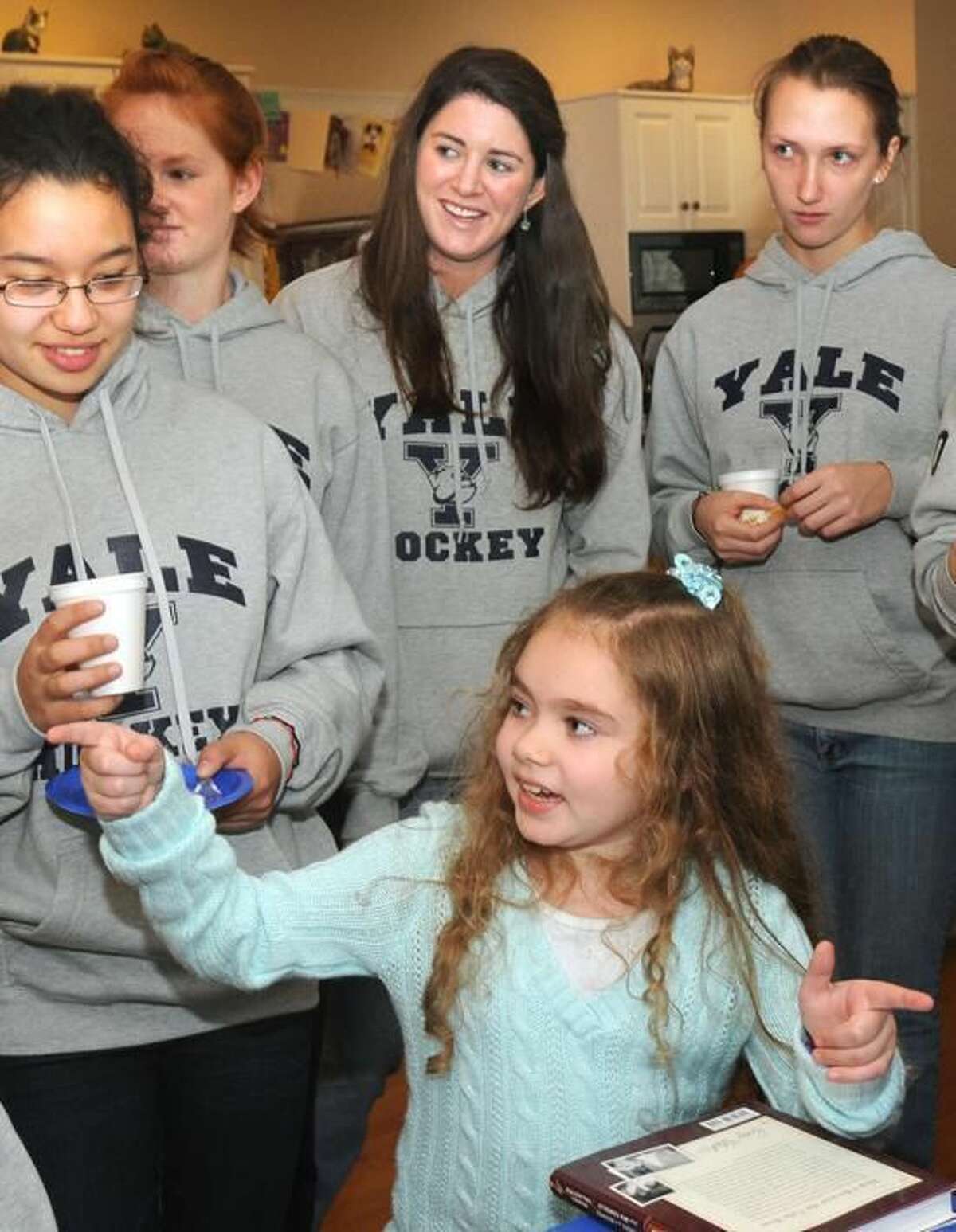The Yale women's hockey team, including Aleca Hughes (center), "adopted" nine-year-old Giana Cardonita of Guilford, who had a benign brain tumor removed. On Thursday, Hughes was honored as the ECAC Hockey Mandi Schwartz Student-Athlete of the Year. (Mara Lavitt/Register file photo)