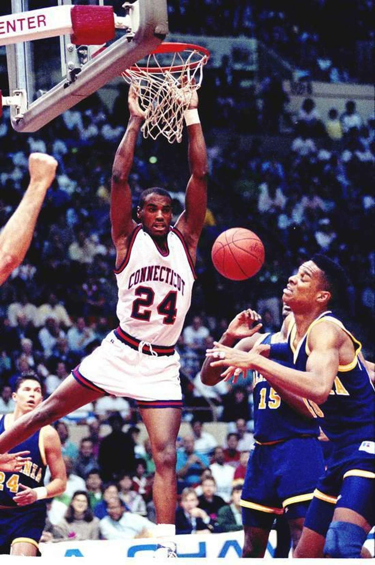UConn's Scott Burrell of Hamden dunks the ball past Byrant Walton, right, and Brian Hendrick (15) of the University of California in the UConn-California game in the second round of the NCAA East Regional playoffs in Hartford, Conn., Saturday, March 17, 1990. (AP Photo/Bob Child)