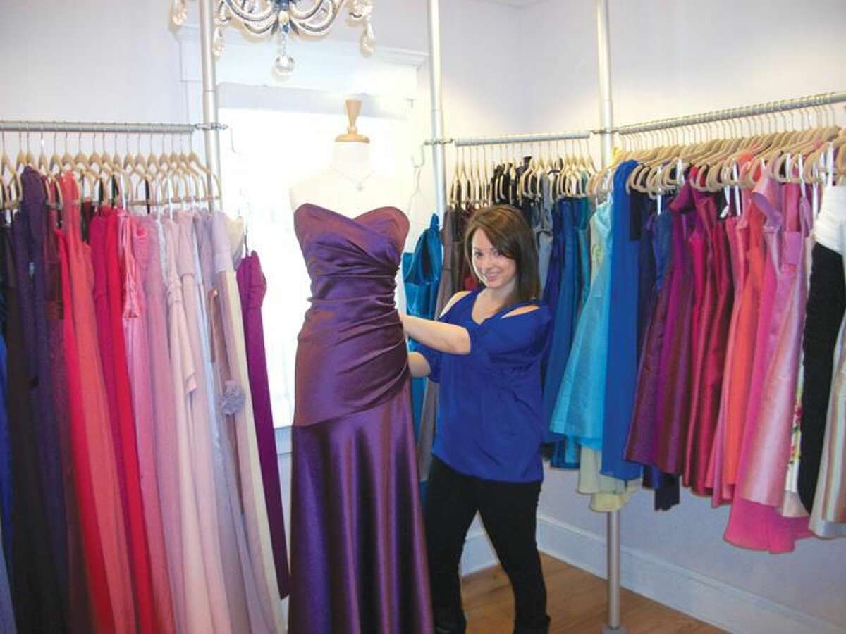 Photo by Lynn Fredricksen Lisa DeLeo adjusts a display gown at her boutique Simply Couture. The shop, at 30 State Street, offers a variety of dresses for proms, brides, and other occasions.