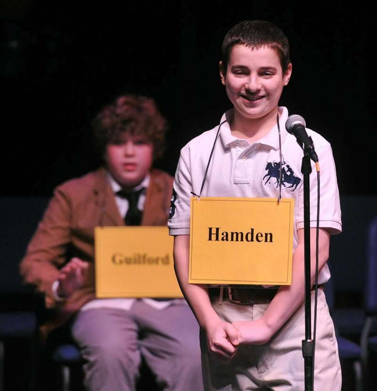 New Haven— Anthony Capasso, 13, from Hamden Hall, smiles as he wins the New Haven Register Spelling Bee at SCSU's Lyman Hall. Behind him is Max Martin, 14, of E.C. Adams Middle School in Guilford, who came in 2nd place. Photo-Peter Casolino/Register