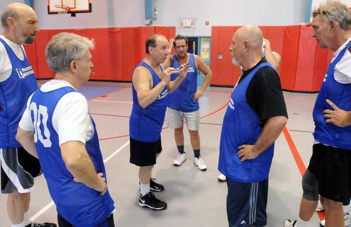 The Wallingford Silver Bullets, a senior basketball team, during a game against Manchester at the Wallingford Parks & Recreation Dept. Mel Horowitz of Wallingford, center, coaches during a time out. Mara Lavitt/New Haven Register