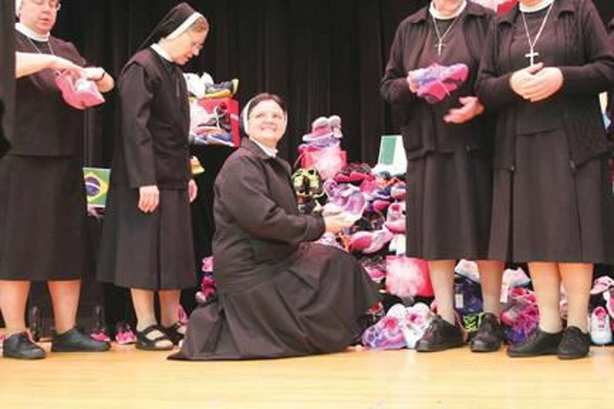 Submitted Photo Above: Sr. Miram Cunha Sobrinha, Provincial Superior of the Sao Paulo Province, receives hundreds of pairs of sneakers collected by the Sacred Heart students for the children of Haiti.