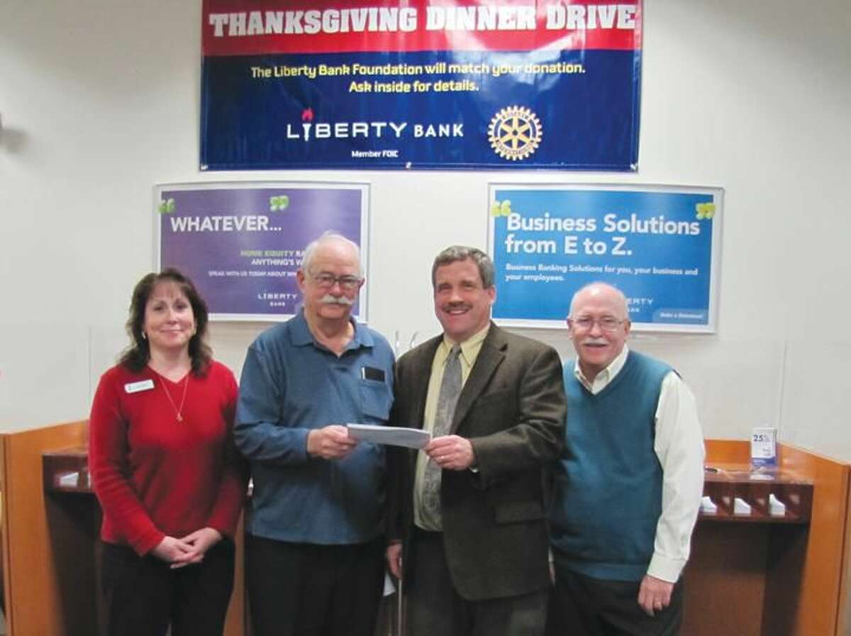 Submitted photo by David Marchesseault, Rotary Publicity Chair North Haven Liberty Bank’s Interim Manager Kimberly Pierce and Rotarian John Henry Graef Jr. present a $6,421.46 check to Rev. Scott G. Morrow as 2013 Rotary Food Drive Chairman Bill Espowood looks on.