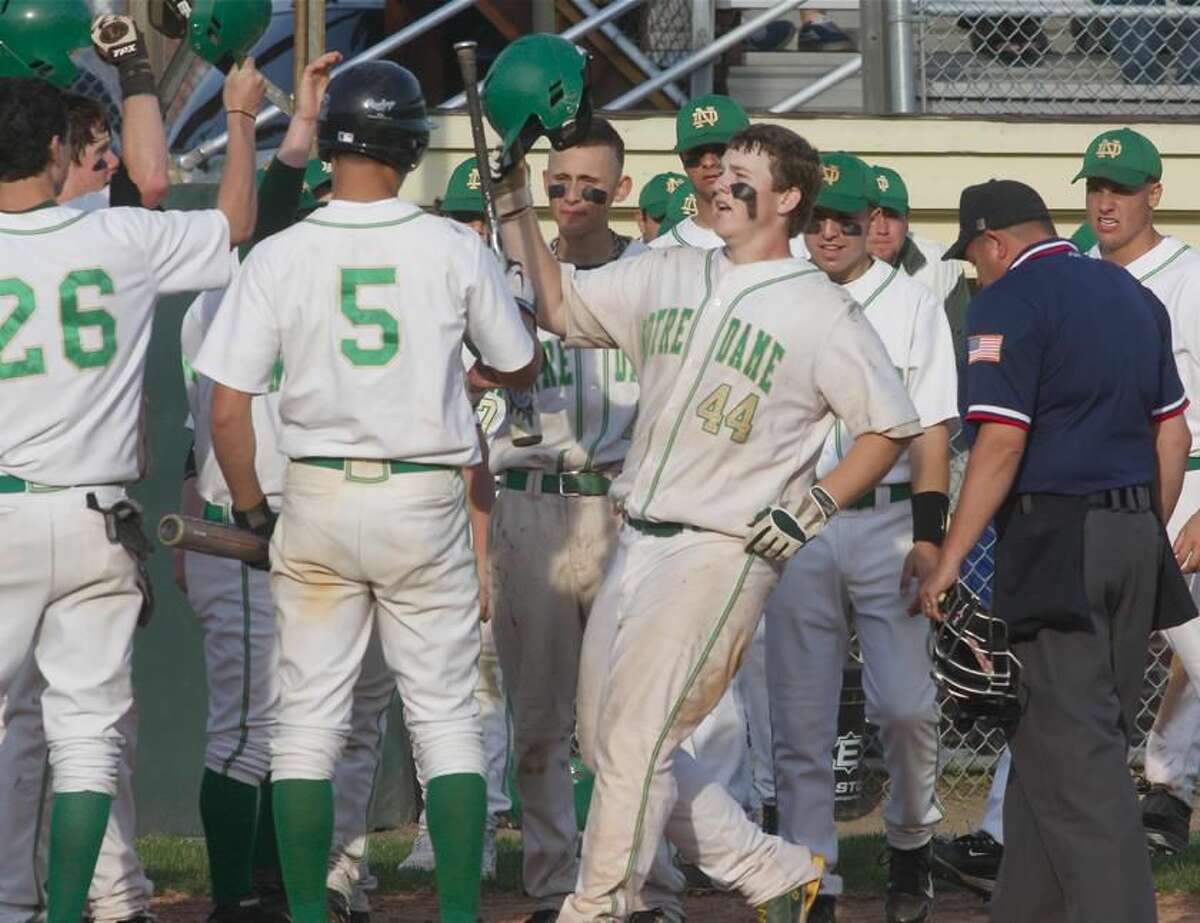 Notre Dame's Dave Beisler is greeted by teammates after hitting a home run against North Haven. While the Green Knights lost that game, 5-4, Beisler earned the win on the mound the previous day in Notre Dame's thrilling 6-5 comeback victory over Shelton. (Photo by Russ McCreven)