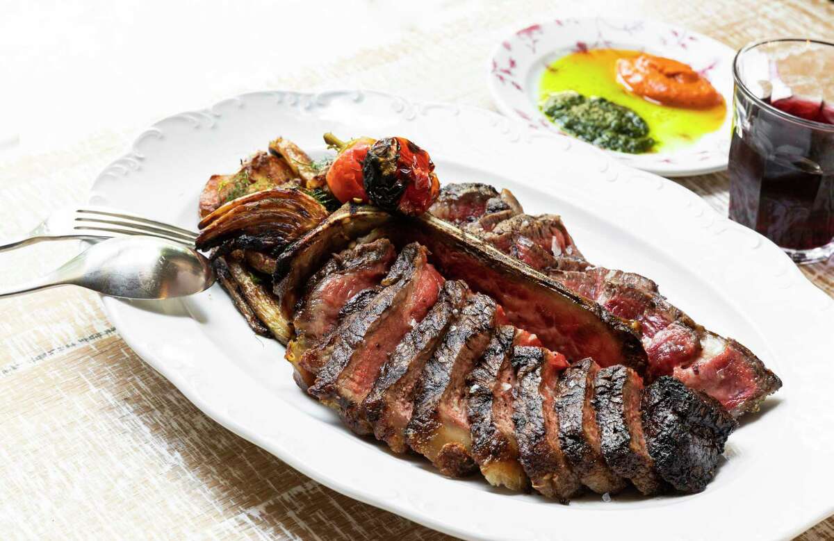 Bistecca Fiorentina (44 Farms steak served with potatoes, fennel, pickled peppers and red and green sauces at Rosalie Italian Soul.