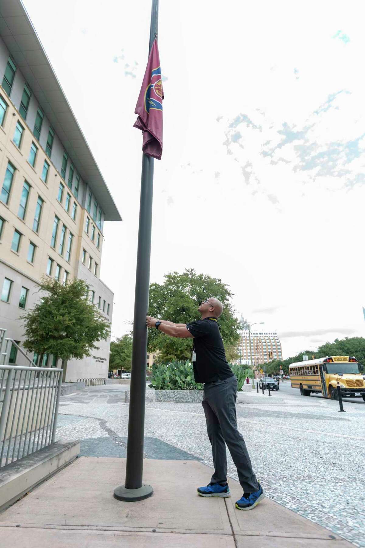 San Antonio Police Department employee Kevin Wilkinson lowers the fire department flag Tuesday, Oct. 15, 2019, in front of Public Safety Headquarters after it was announced Station 1 firefighter Greg Garza had been killed while on a call earlier in the day. Garza had been with the fire department for 17 years.