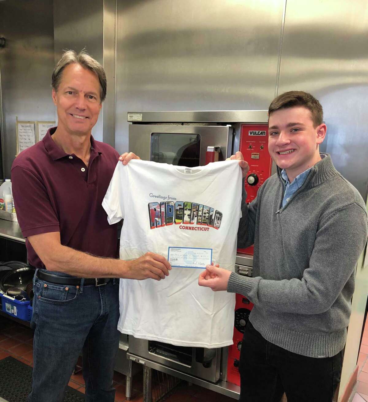 Dean Miller, Chair of Ridgefield Meals on Wheels, receives a donation check from Ridgefield High School senior Sam Sulzinsky.