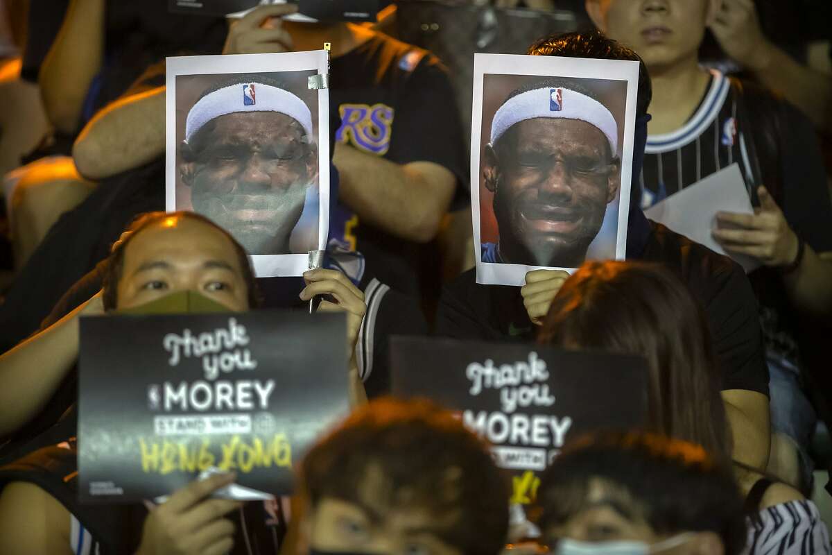 Demonstrators hold up photos of LeBron James grimacing during a rally at the Southorn Playground in Hong Kong, Tuesday, Oct. 15, 2019. Protesters in Hong Kong have thrown basketballs at a photo of LeBron James and chanted their anger about comments the Los Angeles Lakers star made about free speech during a rally in support of NBA commissioner Adam Silver and Houston Rockets general manager Daryl Morey, whose tweet in support of the Hong Kong protests touched off a firestorm of controversy in China. (AP Photo/Mark Schiefelbein)