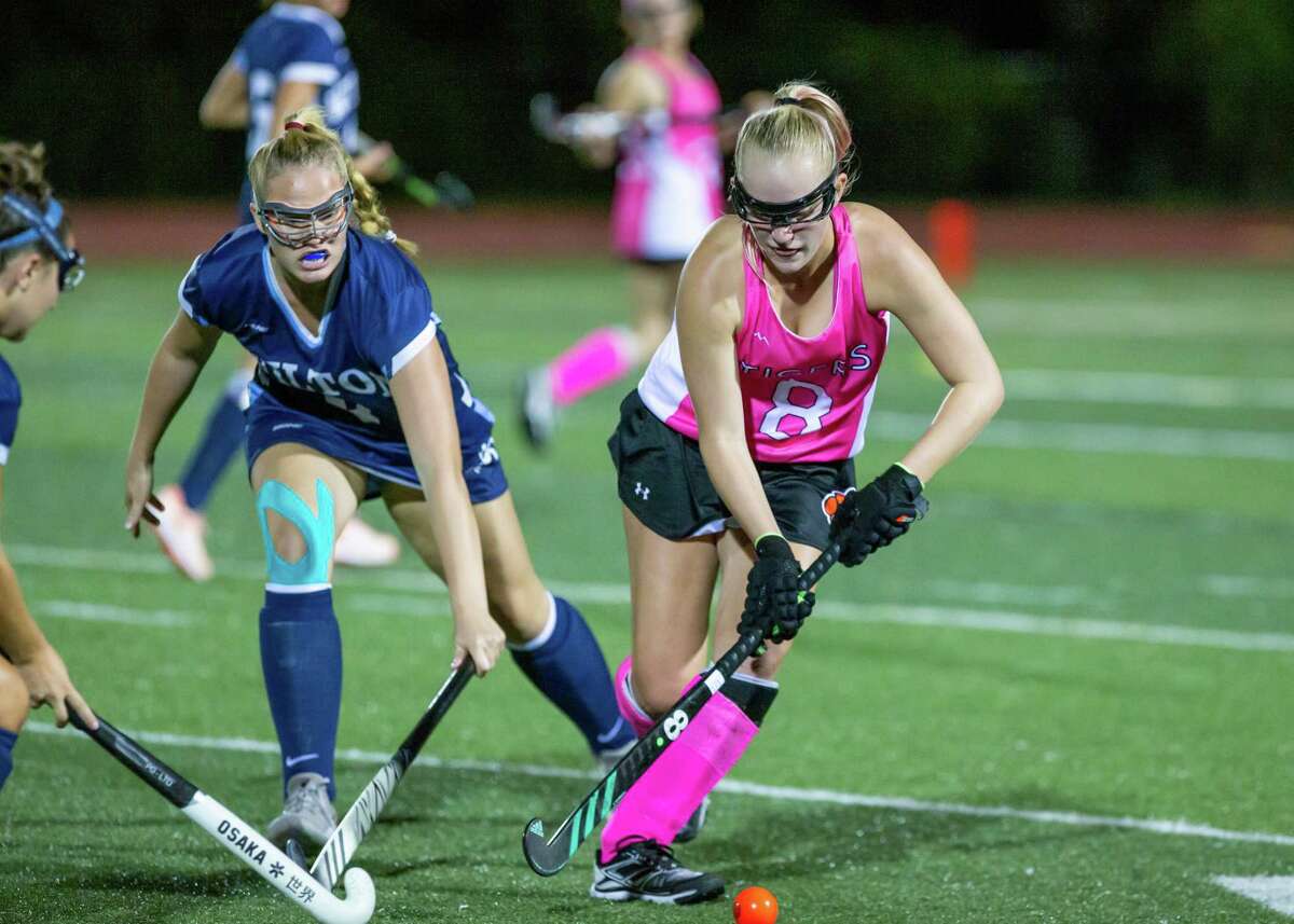 Bailey Harriott (8) keeps the ball away from a Wilton player during a recent field hockey game.