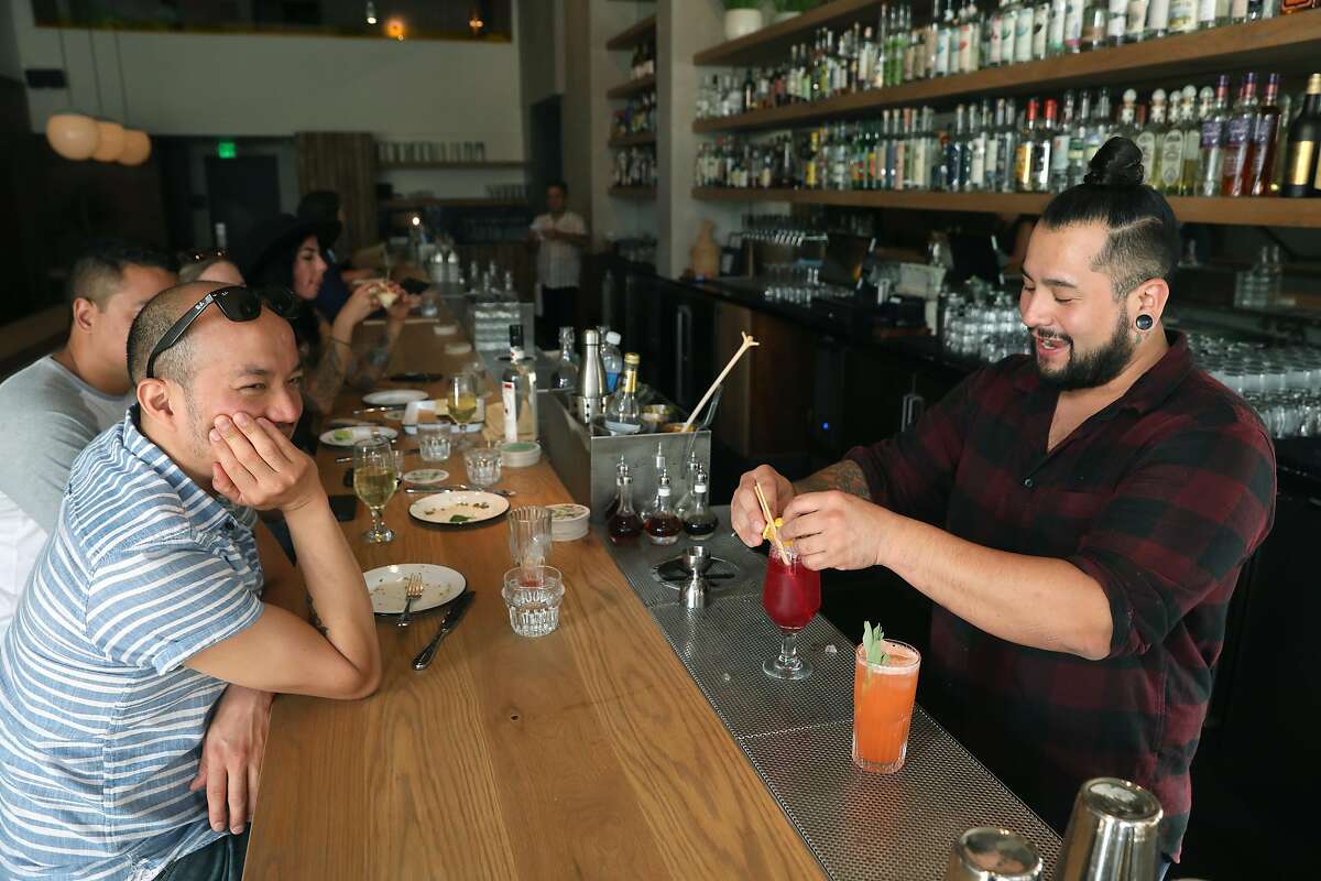 Bartender Christian Suzuki (right) talks with customers including Randy Lee (left front) at Elda while serving drinks on Tuesday, Oct. 8, 2019, in San Francisco, Calif.