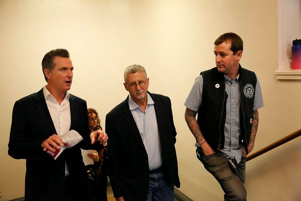 Governor Gavin Newsom (l to r), Jeff Kositsky, director Department of Homelessness and Supportive Housing and Mark Mazza, SFHOT lead clinical supervisor of outreach, speak as Governor Newsom tours Project Homeless Connect at the Bill Graham Civic Auditorium on Wednesday, October 16, 2019 in San Francisco, Calif.