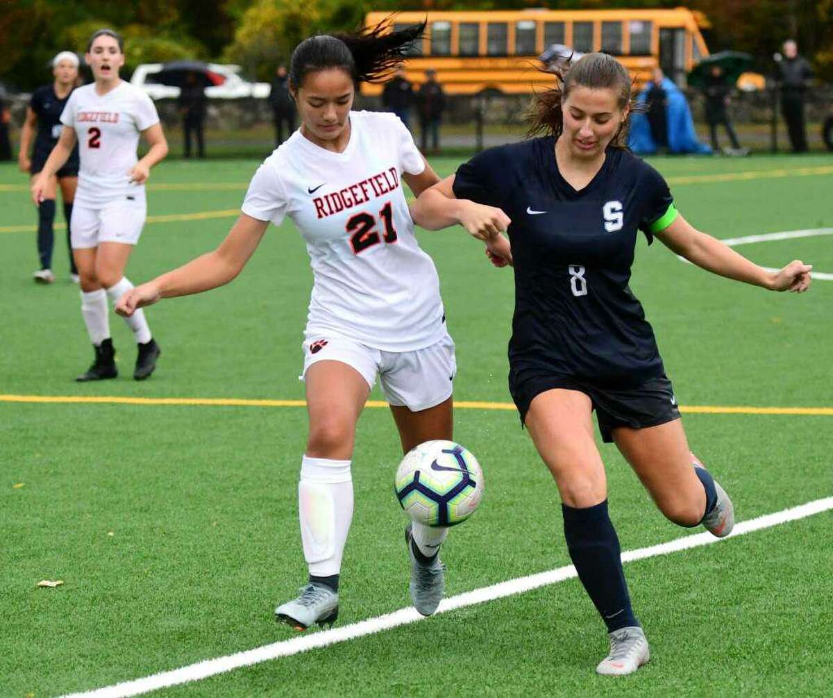 Ridgefield's Alex Kinkead (#21) battles a Staples player for the ball in Wednesday's 0-0 tie in Westport.