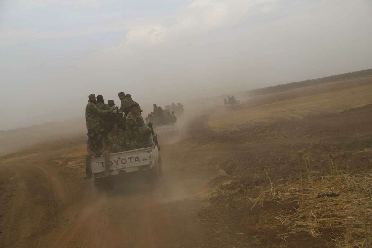 A convoy of Turkish backed Free Syria Army is about to cross into Turkey near the town of Azaz, Syria, Wednesday, Oct. 16, 2019. (AP Photo)