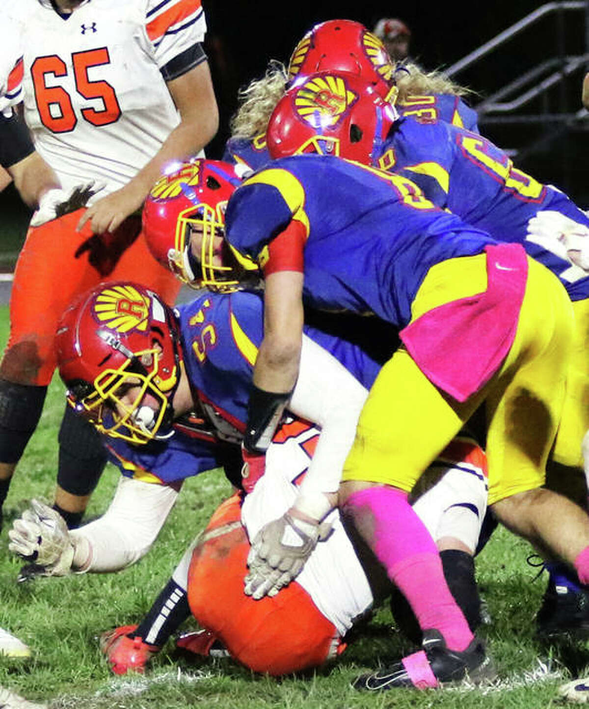 Gillespie running back C.J. Frensko (bottom) is taken down by a stack of Shells on Friday night in Roxana.