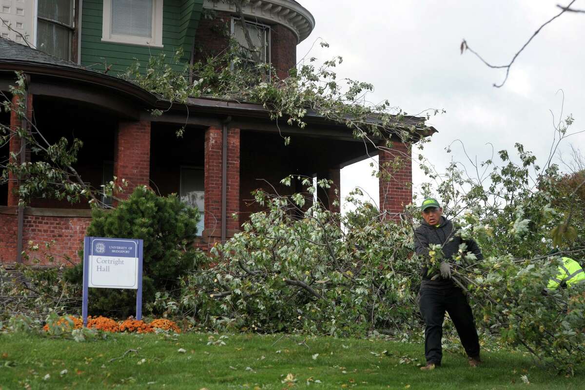 Workers clean up after a tree fell onto the front porch of Cortright Hall during an overnight storm on the campus of the University of Bridgeport, in Bridgeport, Conn. 17, 2019.