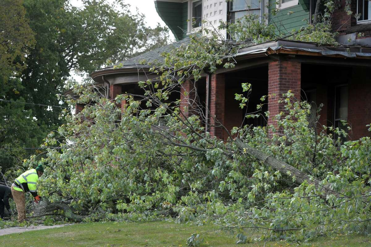 Workers clean up after a tree fell onto the front porch of Cortright Hall during an overnight storm on the campus of the University of Bridgeport, in Bridgeport, Conn. 17, 2019.