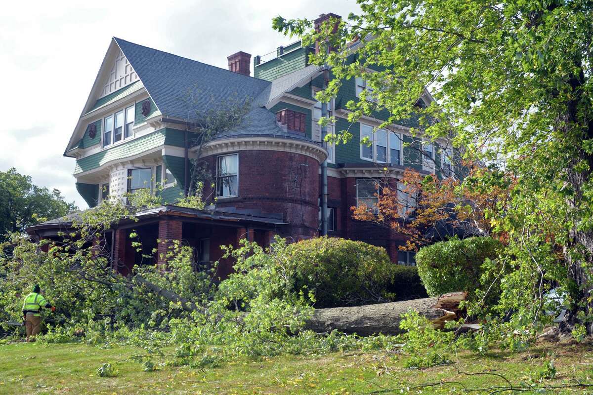 Workers clean up after a tree fell onto the front porch of Cortright Hall during an overnight storm on the campus of the University of Bridgeport, in Bridgeport, Conn. 17, 2019.
