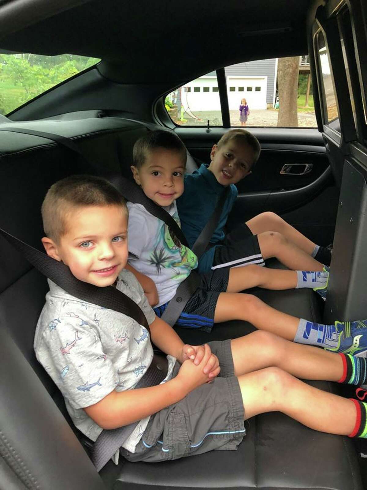 Veterans Park Elementary School students Charlie,Thomas and Henry Cannone won a ride to school with Ridgefield police officer Mark Giglio at the department’s annual Cones and Cops event at Deborah Ann's Sweet Shoppe earlier this fall.