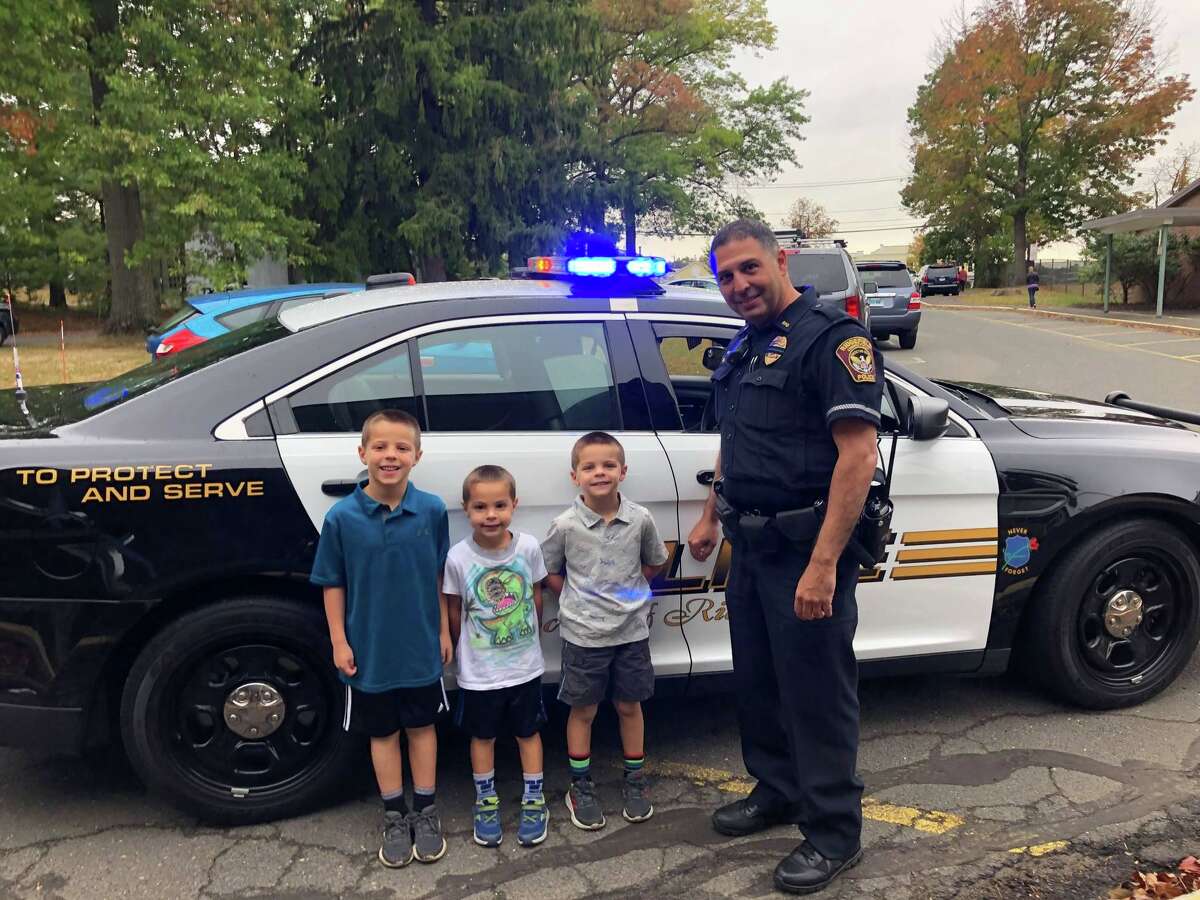 Veterans Park Elementary School students Charlie,Thomas and Henry Cannone won a ride to school with Ridgefield police officer Mark Giglio at the department’s annual Cones and Cops event at Deborah Ann's Sweet Shoppe earlier this fall.