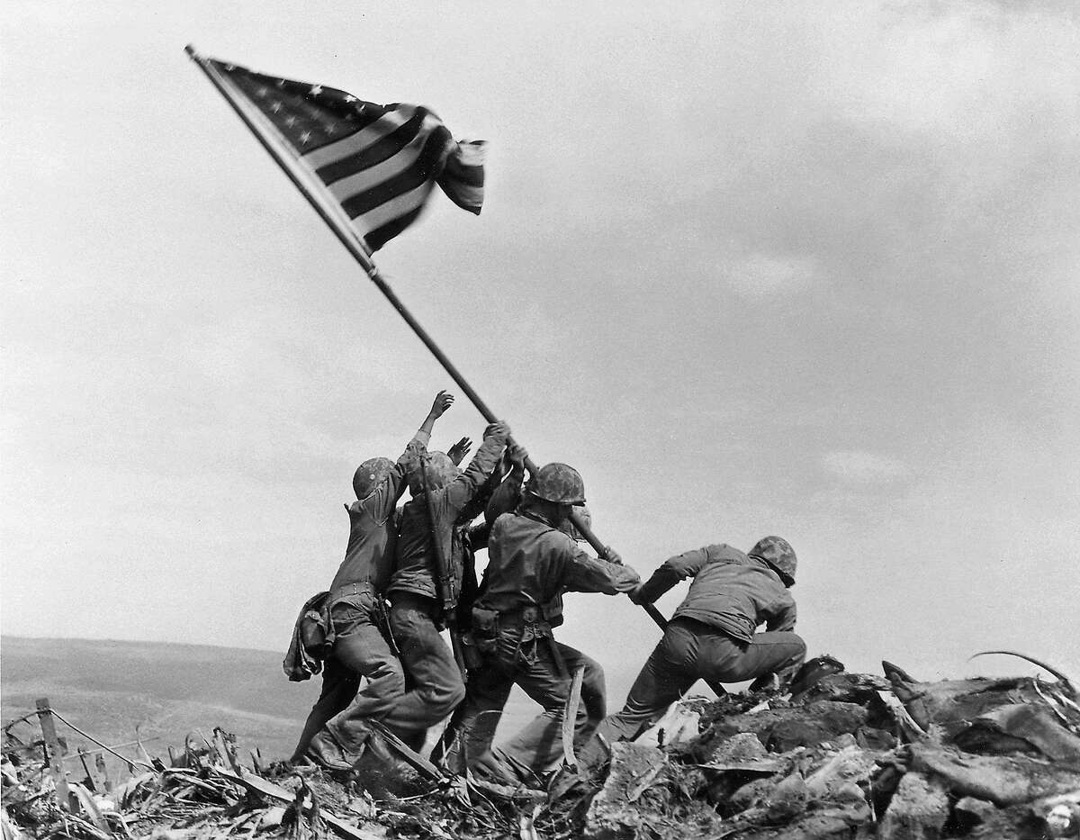 1945年2月23日，美国海军陆战队第5师第28团在硫磺岛的折钵山升起美国国旗。这座太平洋岛屿位于距离东京660英里的战略要地，是二战中最血腥、最著名的一场对日战役的发生地。(美联社图片/乔·罗森塔尔，档案)