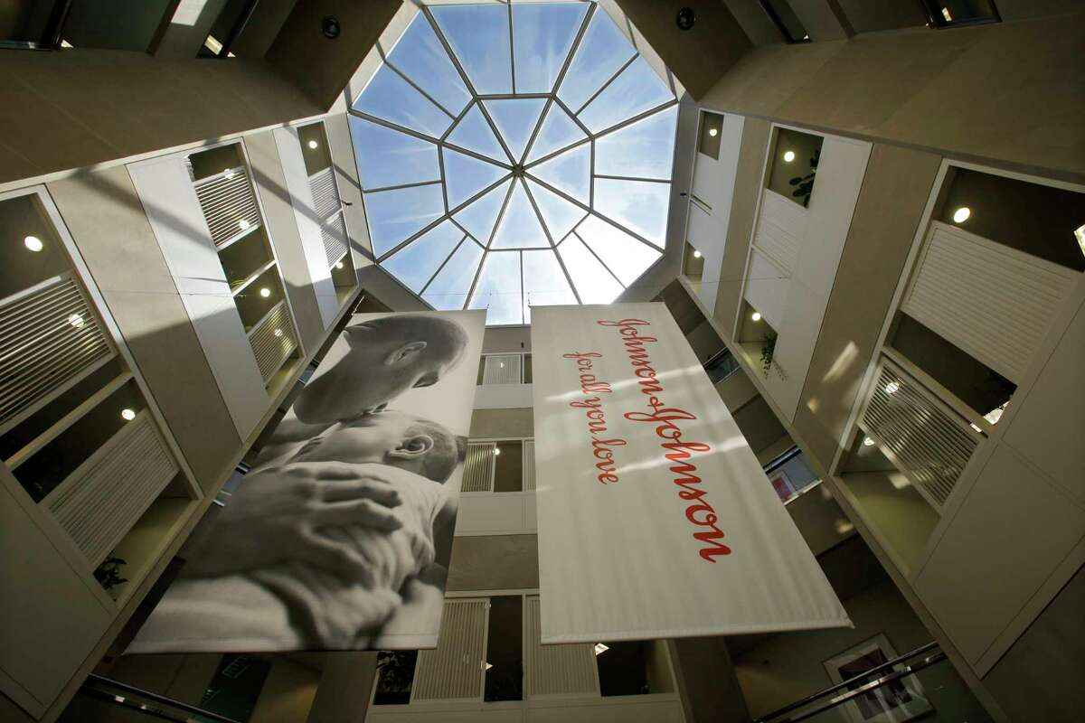 FILE - In this July 30, 2013, file photo, large banners hang in an atrium at the headquarters of Johnson & Johnson in New Brunswick, N.J. Johnson & Johnson has agreed to a $117 million multistate settlement over allegations it deceptively marketed its pelvic mesh products, which support women's sagging pelvic organs. (AP Photo/Mel Evans, File)