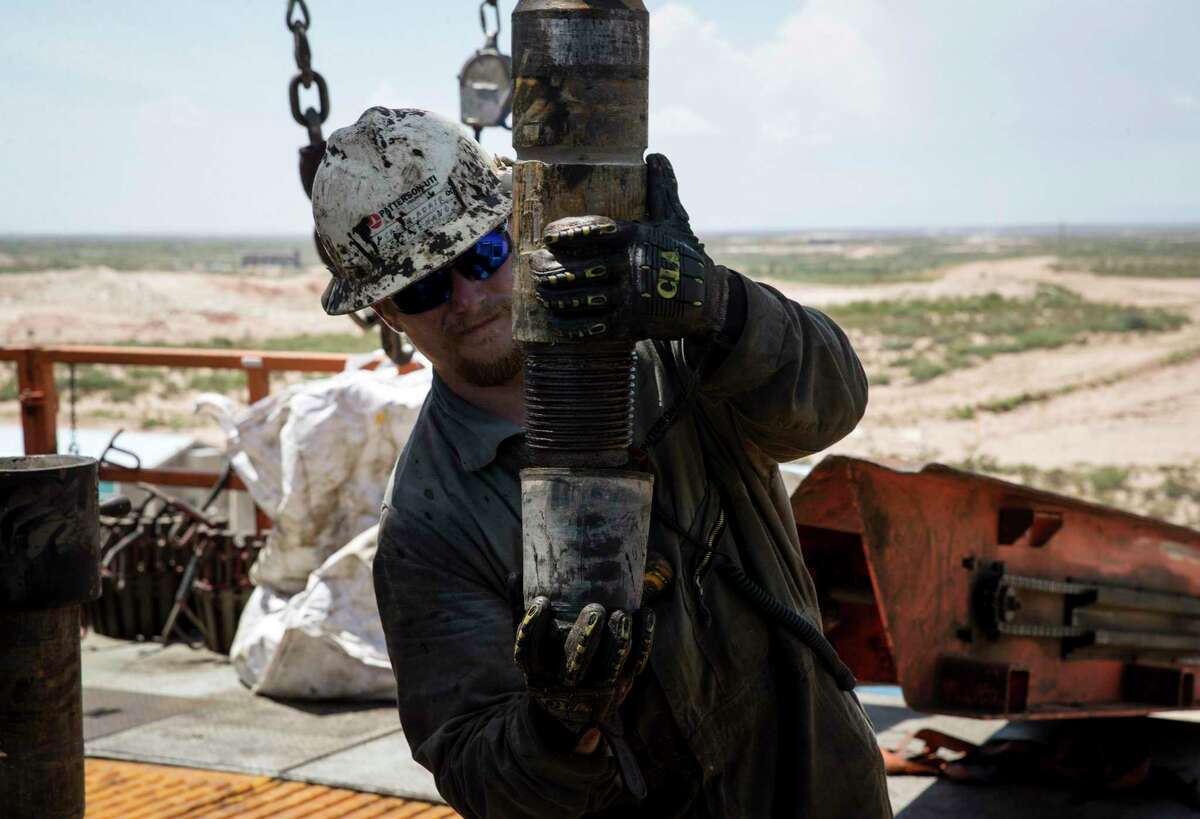 Caleb Adair, a floorhand from Booneville, Ark., builds stands on a drilling rig on Friday, Aug. 23, 2019, near Malaga, N.M. The task consists of joining together three sections of pipe, called "joints."