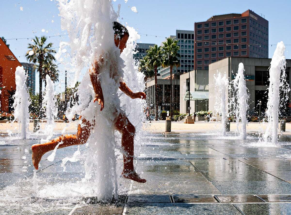 A young boy runs through the fountain at Plaza de Cesar Chavez in downtown San Jose, Calif. Saturday, July 27, 2019.