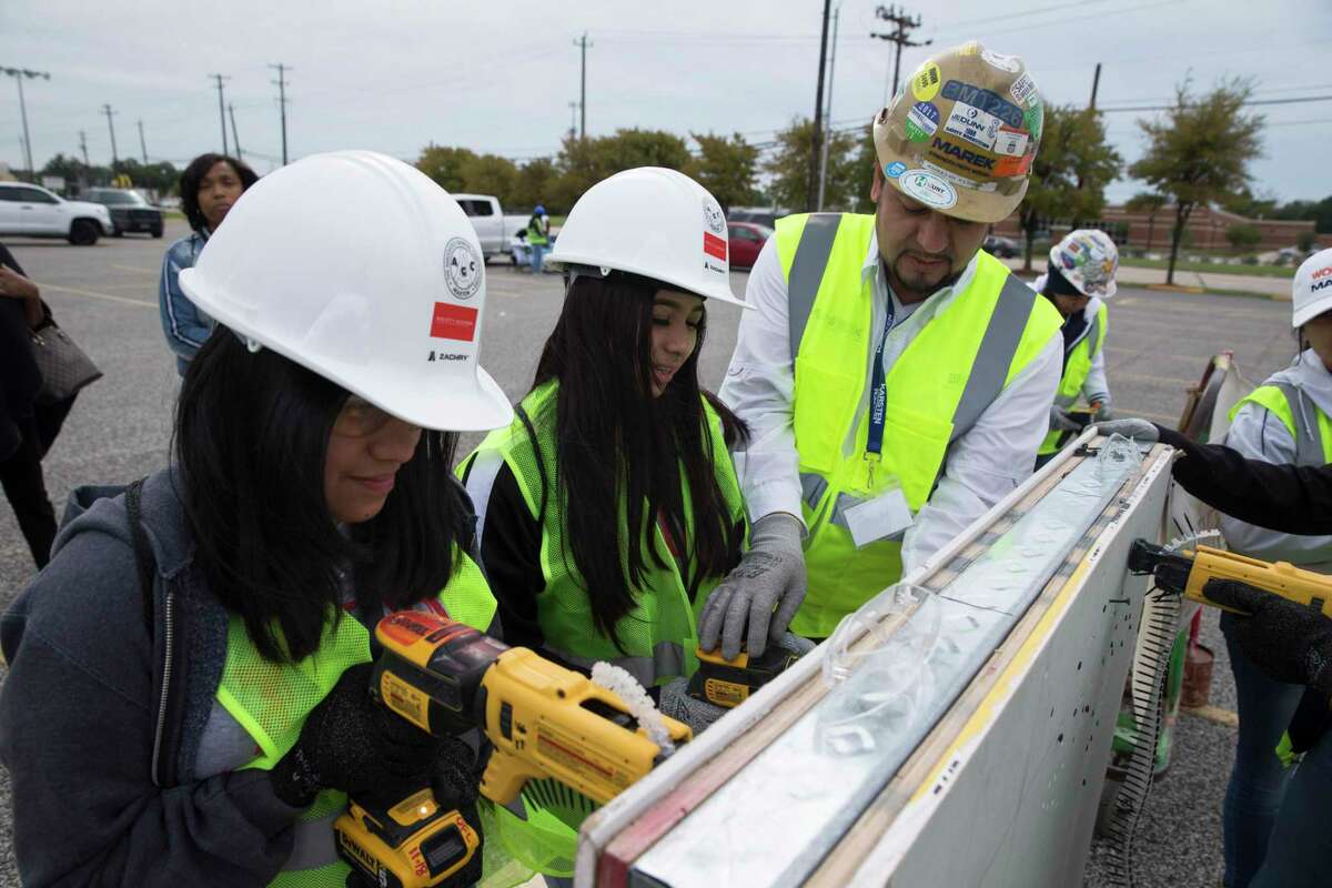 Aurelio Flores, of Marek Brothers Company, teaches MacArthur High School ninth-graders Nayeli Guzman, left, and Yeferly Orozco how to put a nail in the drywall at M.O. Campbell Educational Center on Thursday, Oct. 17, 2019, in Houston. More than 1,000 girls from the Aldine ISD participated in She Builds Houston, a conference for middle and high school students aimed at encouraging girls to join the construction industry.