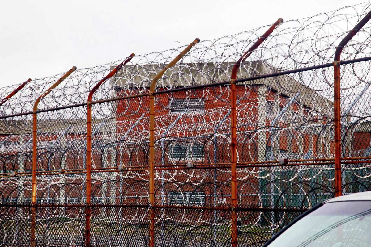 FILE - In this March 16, 2011, file photo, a security fence surrounds inmate housing on the Rikers Island correctional facility in New York. New York City lawmakers are considering a plan to close the notorious Rikers Island jail complex and replace it with four smaller jails. The City Council is set to vote Thursday, Oct. 17, 2019 on a plan to build the jails that would replace Rikers.(AP Photo/Bebeto Matthews, File)