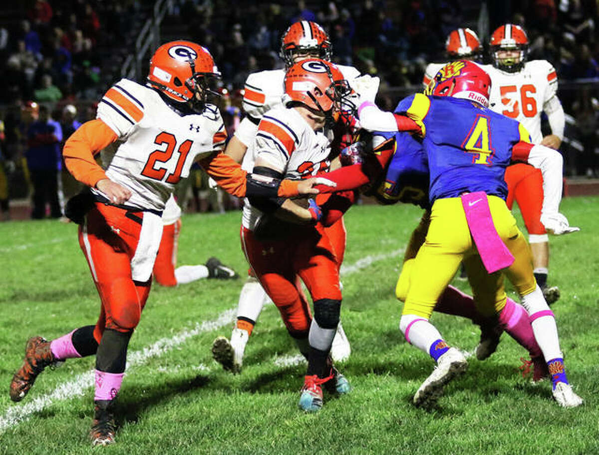 Roxana’s Jacob Sido (4) tries to tackle Gillespie RB John Berry, who draws a facemask penalty on the Shells while QB Frankie Barrett (21) tries to get out front for a block Friday in Roxana.