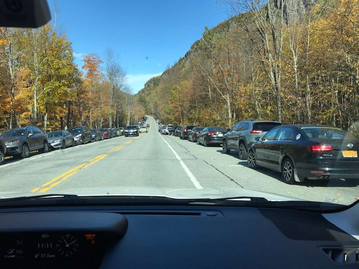 Cars line the shoulder along Route 73 in the Adirondacks High Peaks region.