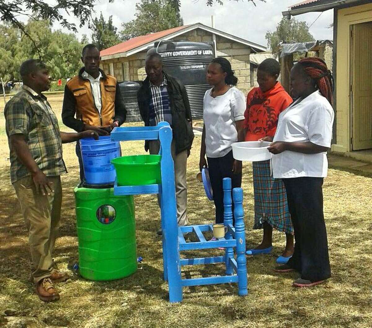 Kenyan villagers receive instructions on how to care for their new water filter.