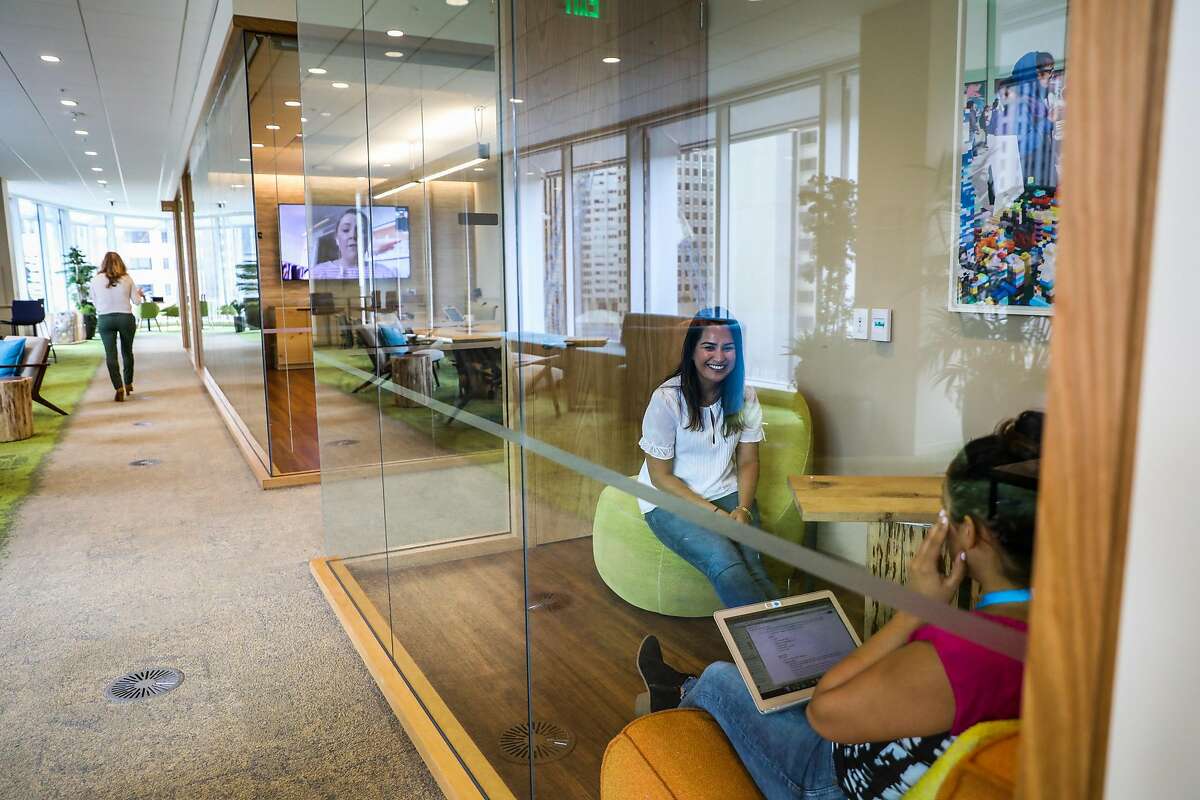 Salesforce employees Shantel Villarroel (right) and Pooja Deopura (center) work on the 8th floor of the Salesforce tower in San Francisco, California, on Wednesday, Sept. 12, 2018.