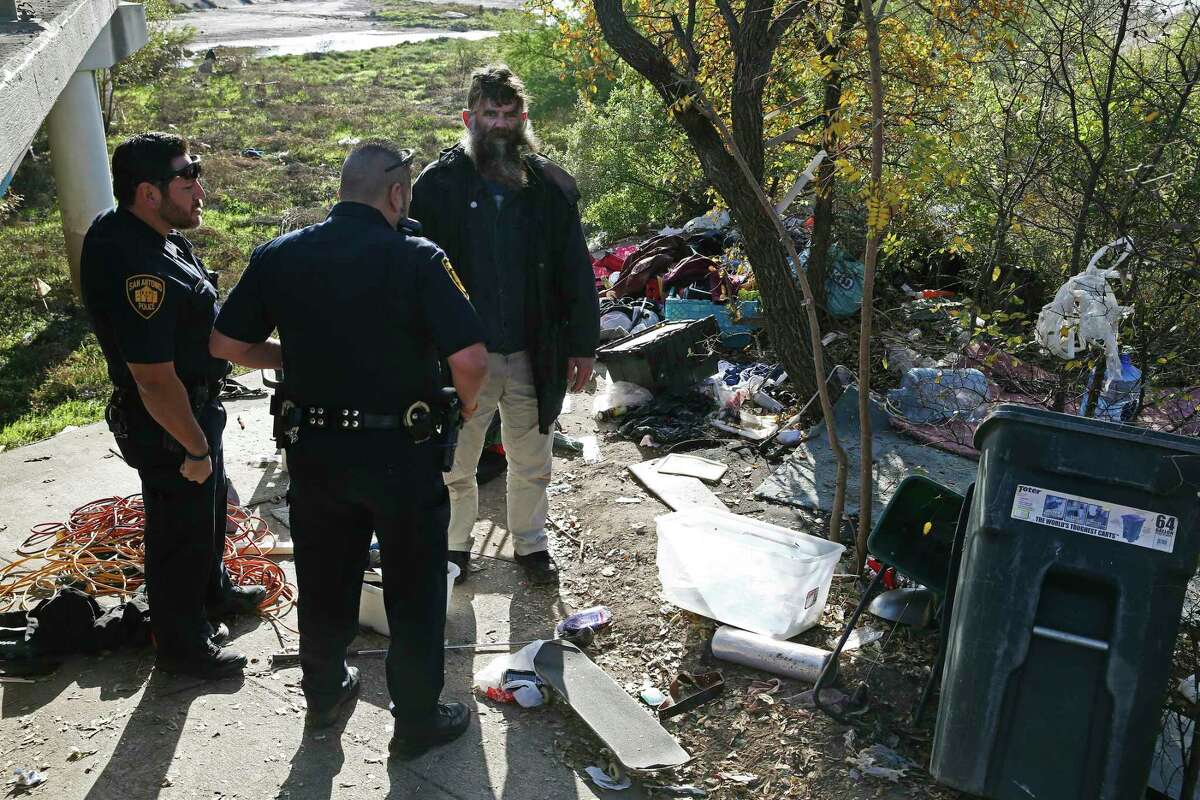 Leland Ray Wood, 51, formerly of Lancaster, California, talks with San Antonio Fear Free Environment Officers Johnny Perez, left, and Elliott Valdez, at an encampment by a bridge on Culebra Road, Dec. 4, 2018. The city is receiving help from California to address homelessness. A reader finds it ironic.
