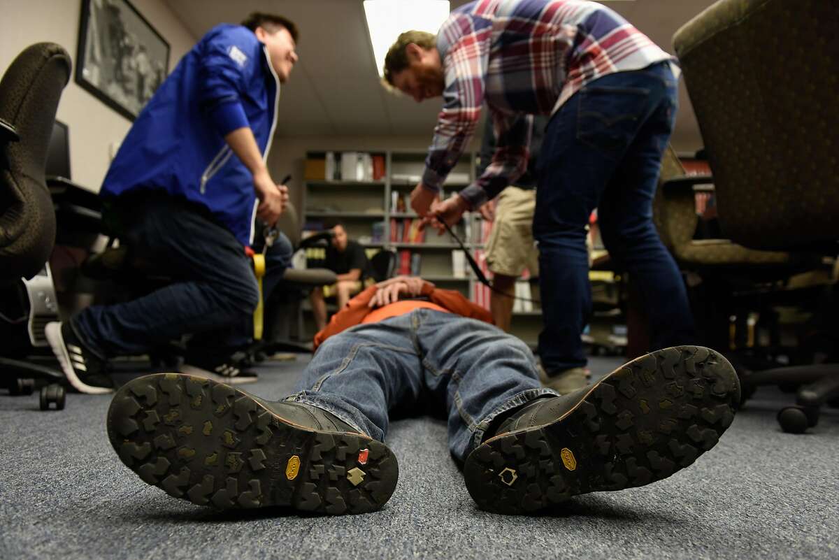 John Fernandes (center) portrays being injured while Jeff Deng (left) and Brian Klosfas tend to his injuries during a triage drill at a San Francisco Fire Department's NERT (Neighborhood Emergency Response Team) training class on September 26, 2019 in San Francisco, Calif.