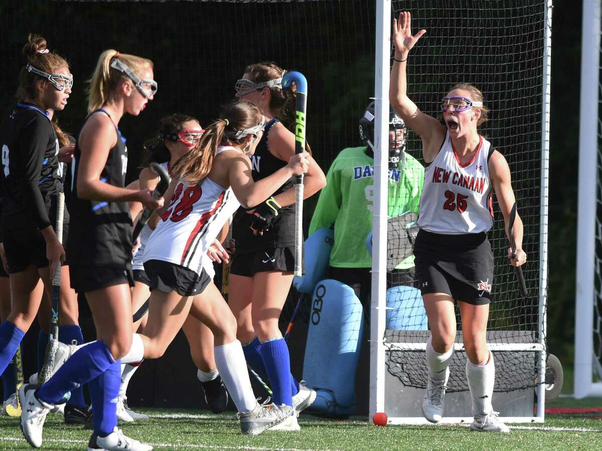 The New Canaan Rams, including Polly Parsons-Hills (25) and Marlee Smith (28) celebrate a goal in the first half during their field hockey game against Darien at Dunning Field on Friday, Oct 18, 2019.