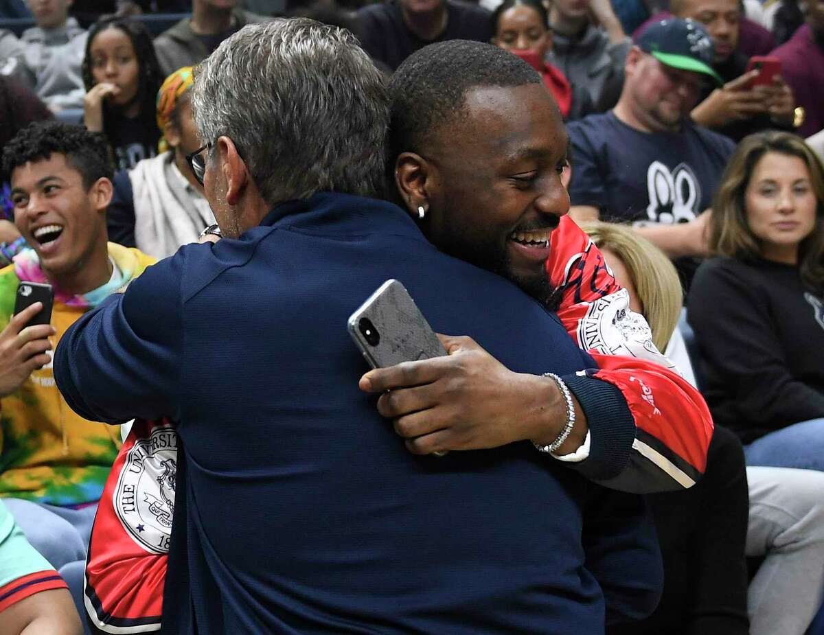 Boston Celtics' and former Connecticut player Kemba Walker, right, embraces Connecticut women's head coach Geno Auriemma during UConn's men's and women's basketball teams' annual First Night celebration in Storrs, Conn, Friday, Oct. 18, 2019. (AP Photo/Jessica Hill)