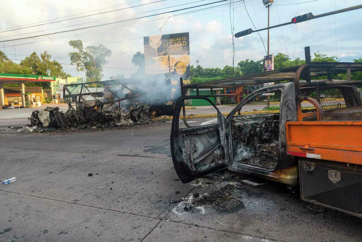Burned vehicles used by armed men continued to burn on the street, one day after clashes between gunmen and law enforcement in Culiacán, Mexico, on Friday, October 18, 2019.
