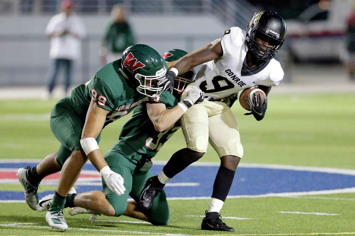 Conroe wide receiver Jalen Williams (9) is caught by The Woodlands' Simon Cruz (99) and Noah Polotko (33) during the first half of their game at Woodforest Bank Stadium Friday, Oct. 18, 2019 in Shenandoah, TX.