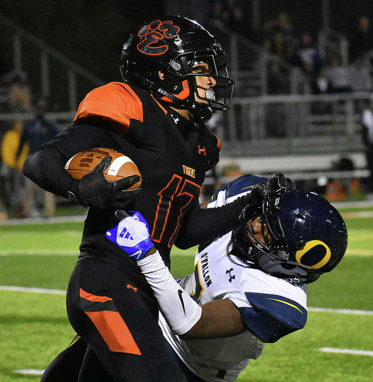 Edwardsville wide receiver Ethan Young delivers a stiff-arm to an O’Fallon defender after making a reception in the first quarter Friday.