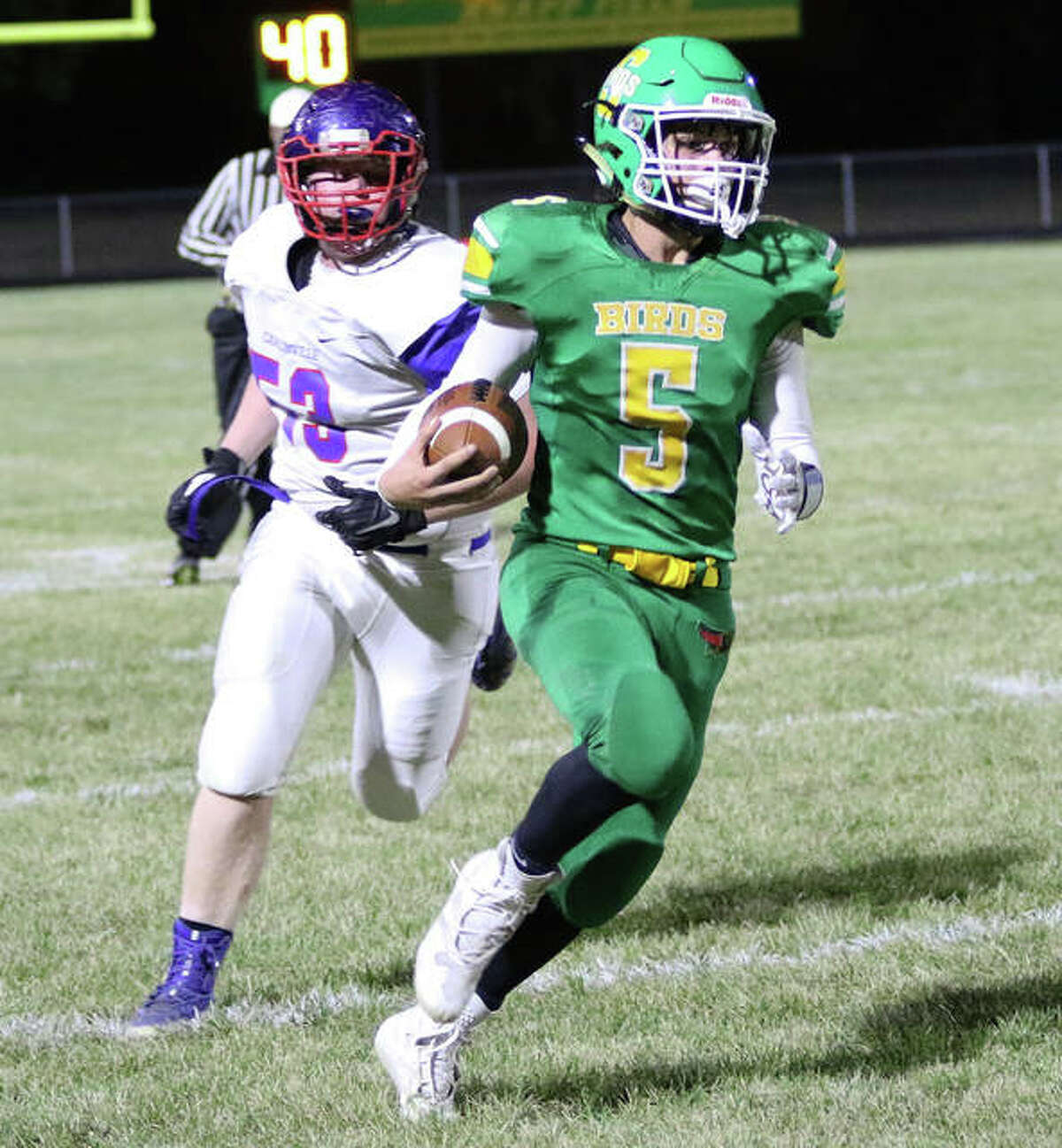 Southwestern’s Gavin Day (5) heads upfield after getting around Carlinville’s Tyler Reels in the first half Friday night at Knapp Field in Piasa.