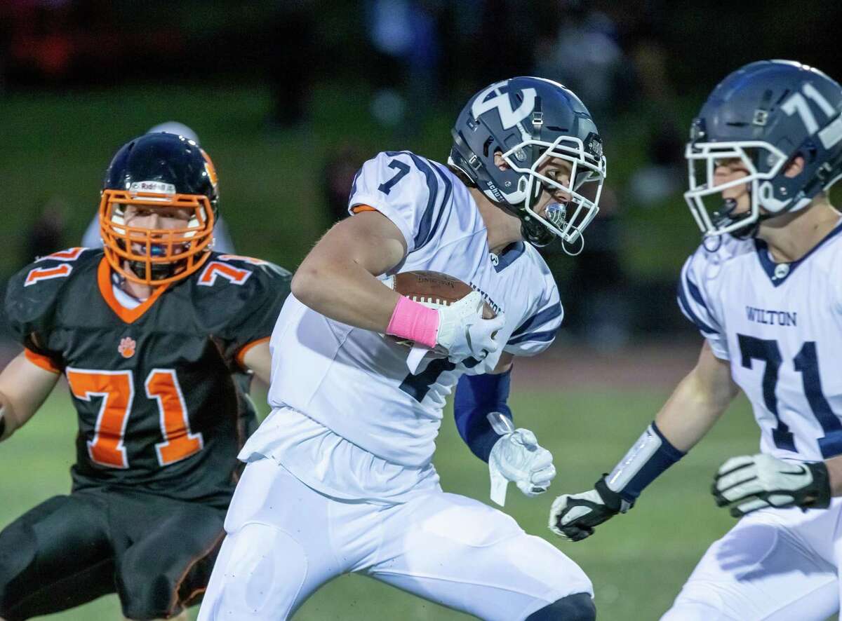 Mike Coffey gains yardage after making a catch in Friday's loss to Ridgefield.