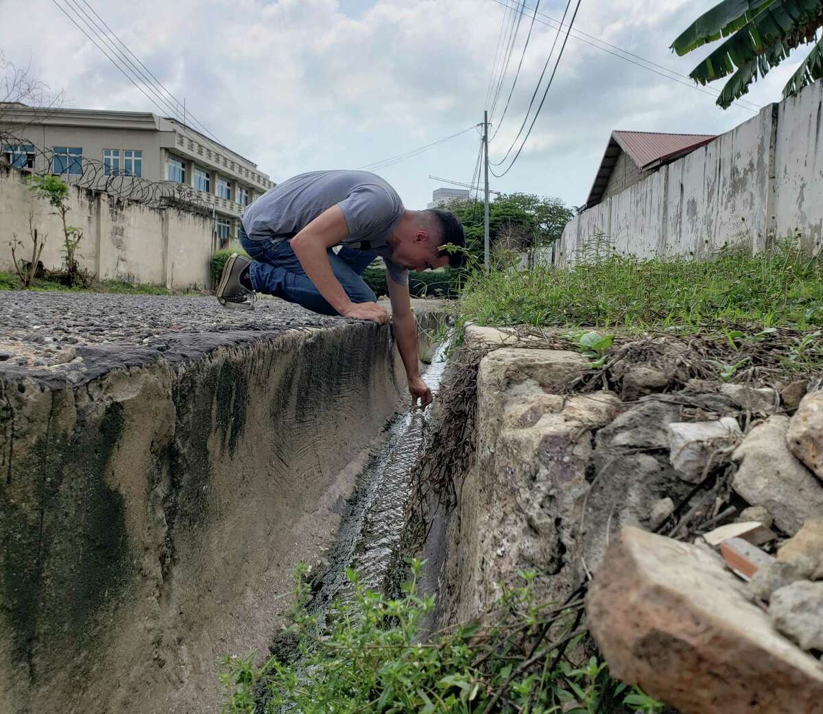 Ben Chan, a research scientist, at Yale University, collects phages, viruses that kill bacteria, in a sewage ditch in Accra, Ghana, last week.