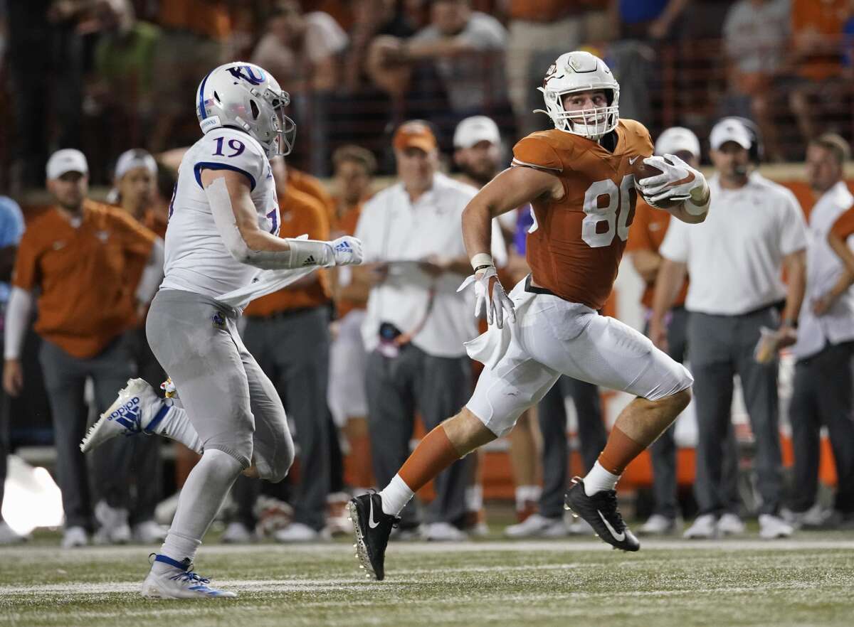 Texas' Cade Brewer (80) runs after a catch as Kansas' Gavin Potter (19) chases him during the second half of an NCAA college football game in Austin, Texas, Saturday, Oct. 19, 2019. (AP Photo/Chuck Burton)