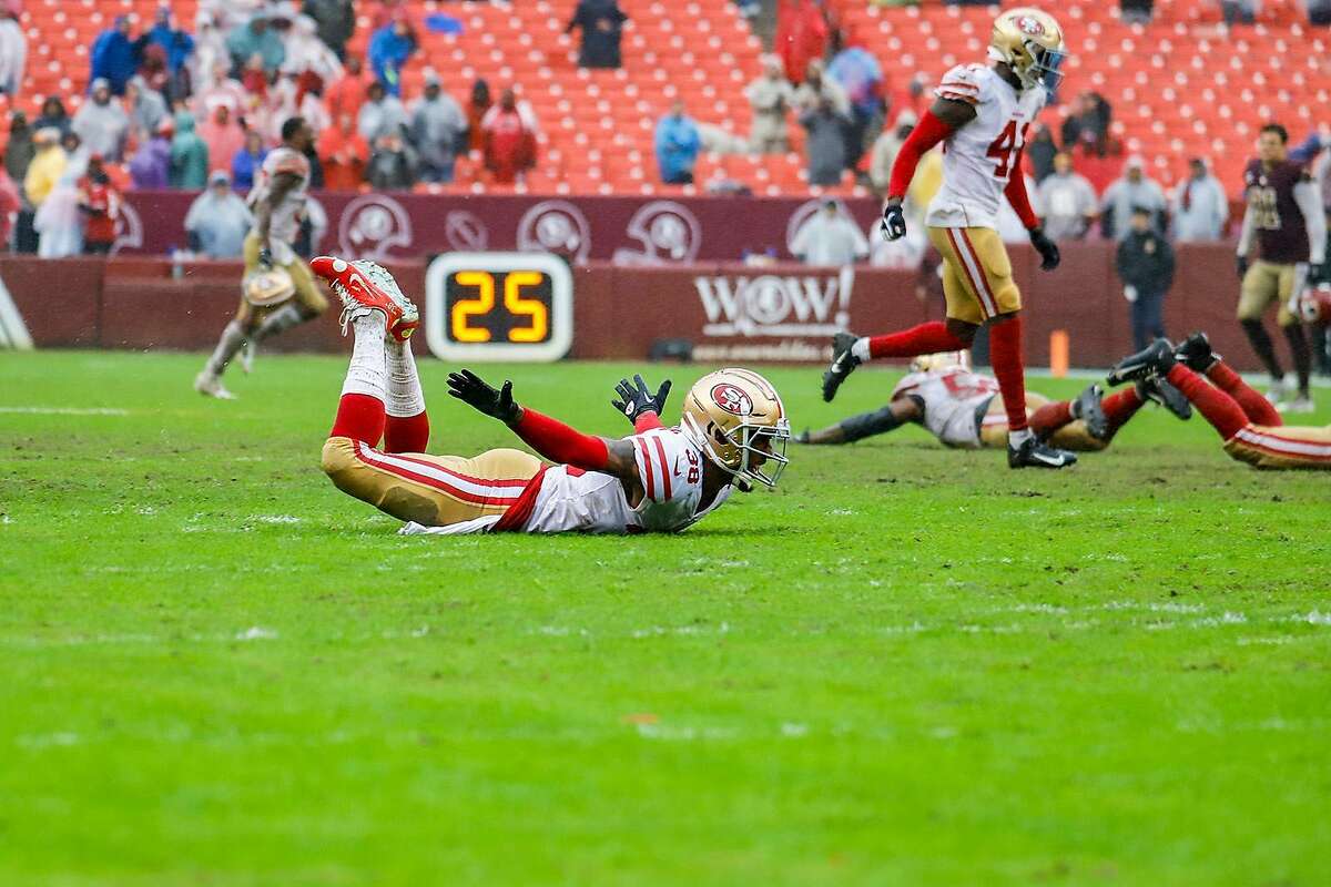 San Francisco 49ers players celebrate their win against the Washington Redskins by sliding on the rain soaked grass at FedExField on October 20, 2019 in Landover, Maryland. (Darryl Smith/TNS)