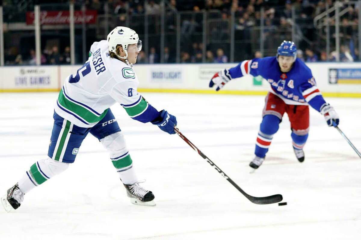 Vancouver Canucks right wing Brock Boeser (6) shoots with New York Rangers right wing Jesper Fast (17) of Sweden defending in the first period of a NHL hockey game, Sunday, Oct. 20, 2019, in New York. Boeser scored on the shot. (AP Photo/Kathy Willens)