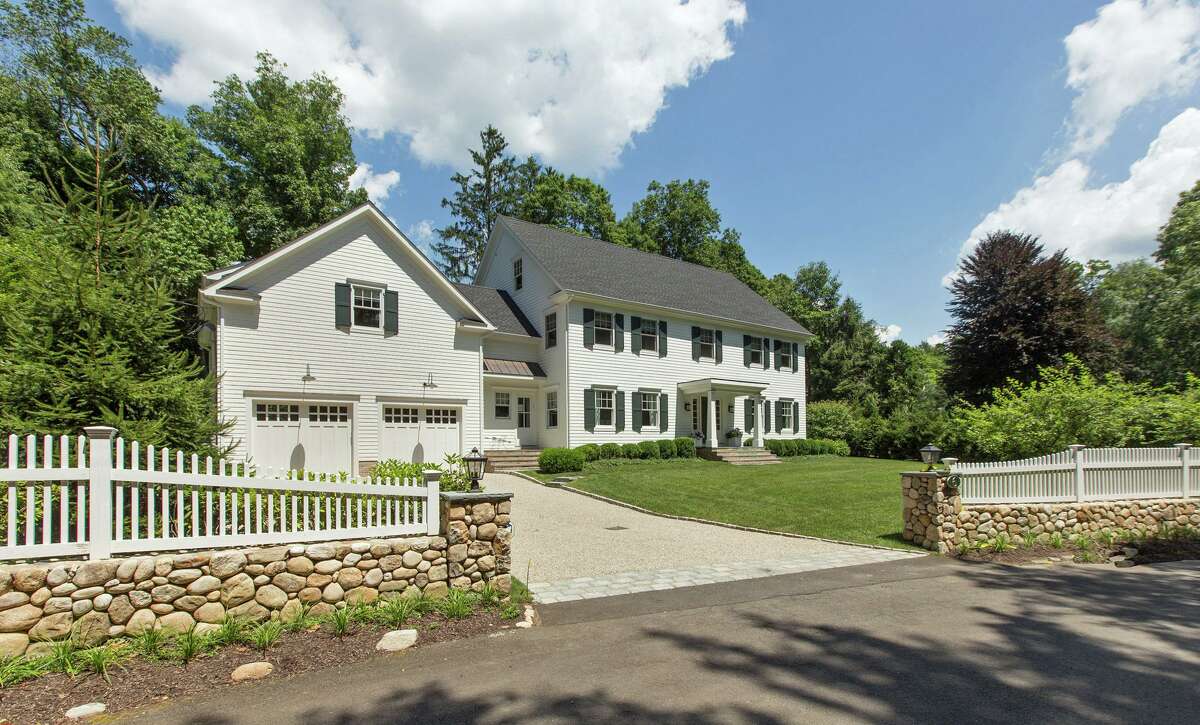 The 7,316-square-foot house sits behind stone and picket fencing in Westport close to the Weston border.