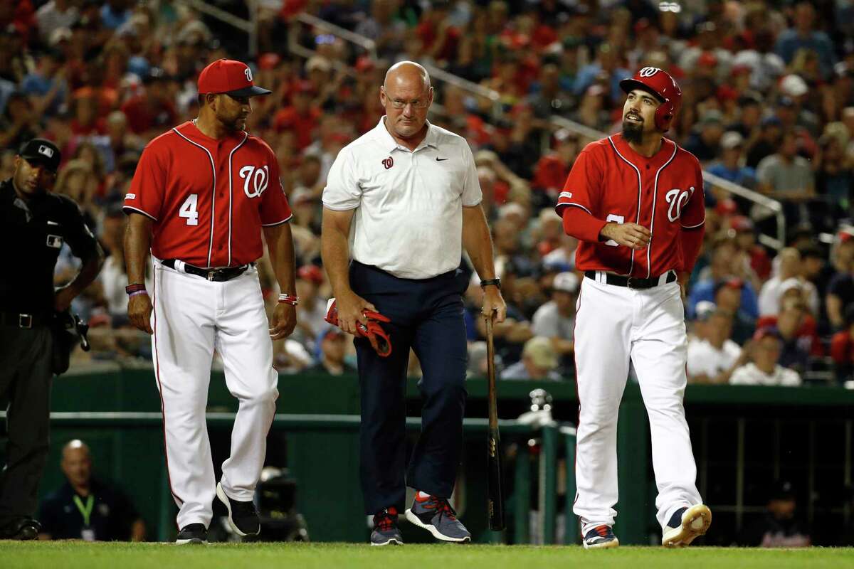 The Nationals’ Anthony Rendon, right, walks to first alongside manager Dave Martinez, left, and head athletic trainer Paul Lessard, center, during a game against the Braves earlier this season.