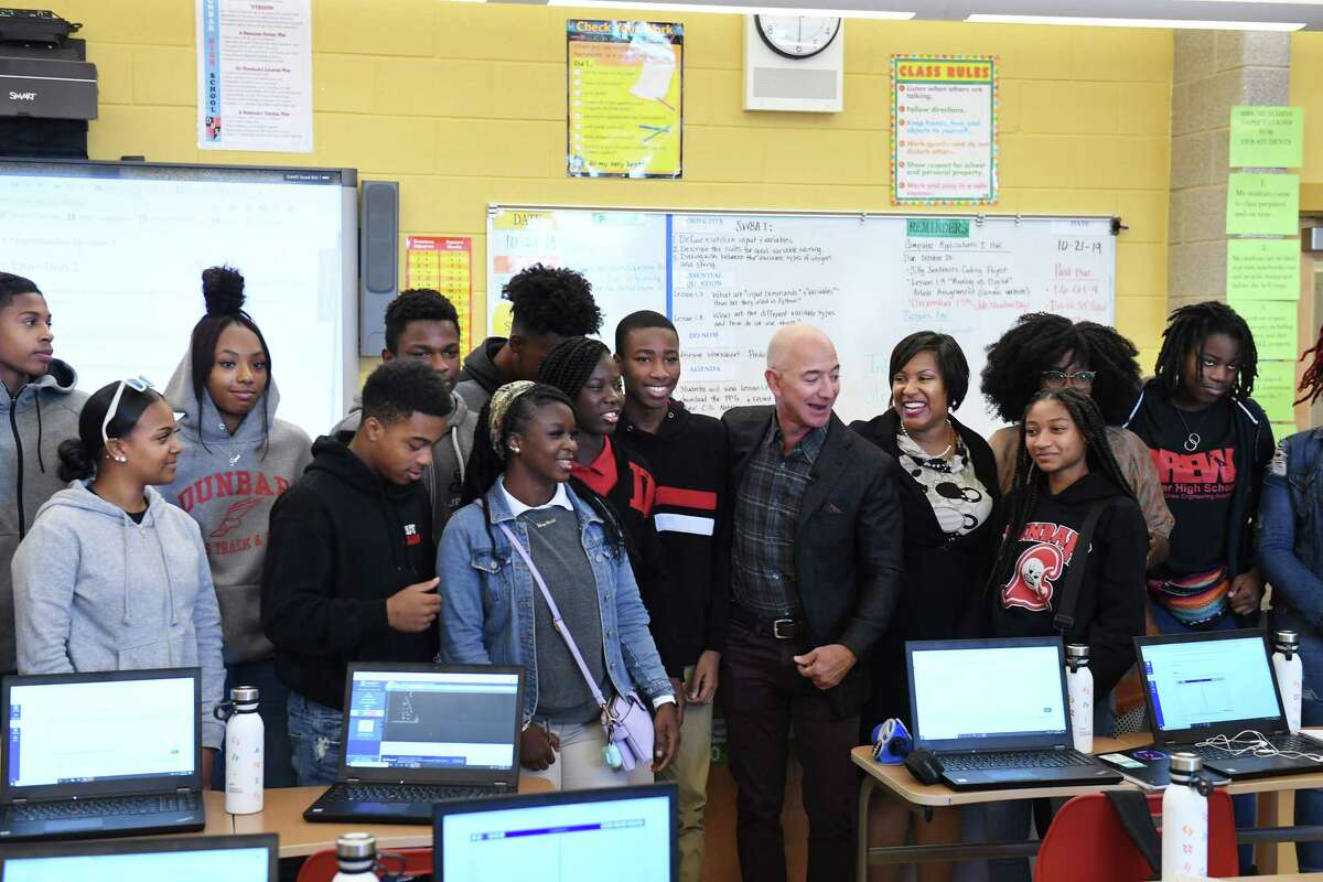 Amazon CEO Jeff Bezos poses for photographs with teacher Ramona Hutchins and the students in her computer science class, which is being funded by Amazon.